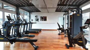 A gym with treadmills, elliptical machines, and a stationary bike.