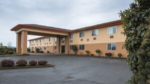A multi-story hotel with a covered entrance and a parking area.