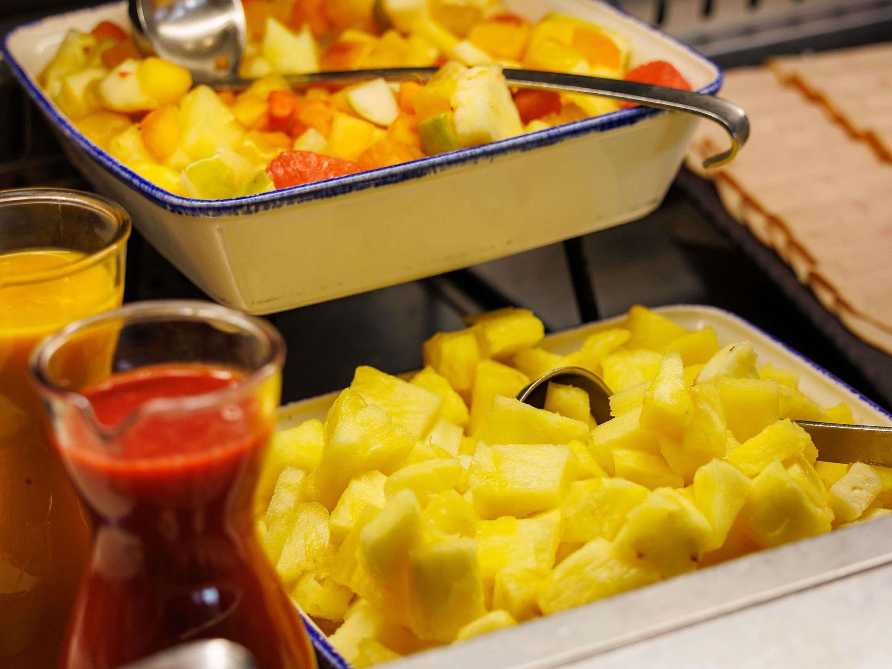 A buffet with fruit dishes and condiments.