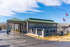 Hotel features a covered entrance with a canopy and a pool.