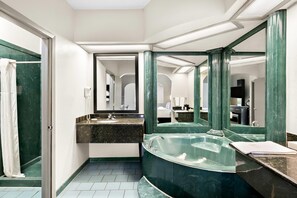 A bathroom with a large mirror, a bathtub, a sink, and a shower. - Quality Inn & Suites Monticello (Monticello)