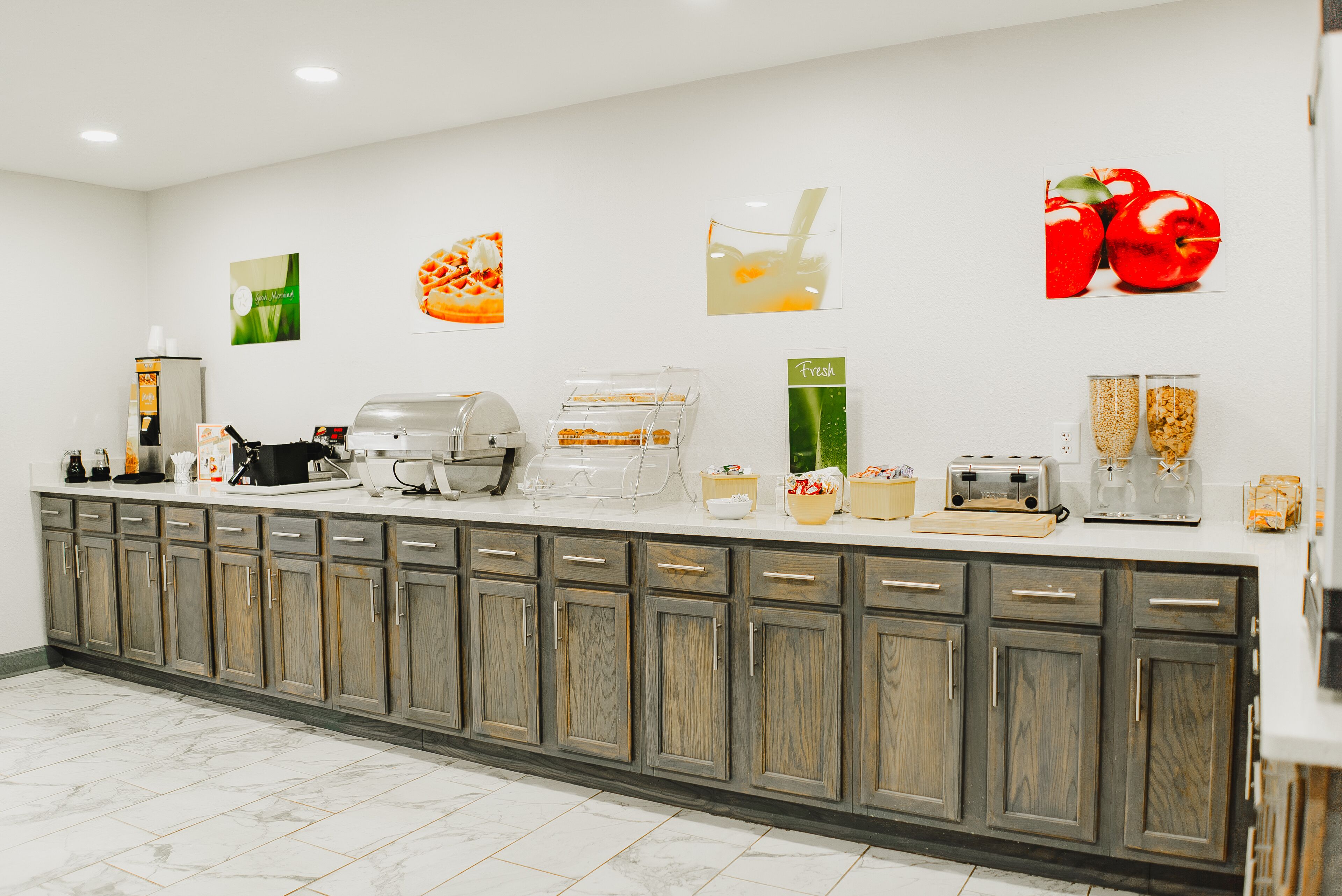 A kitchen area with a counter, wooden cabinets, and various appliances.