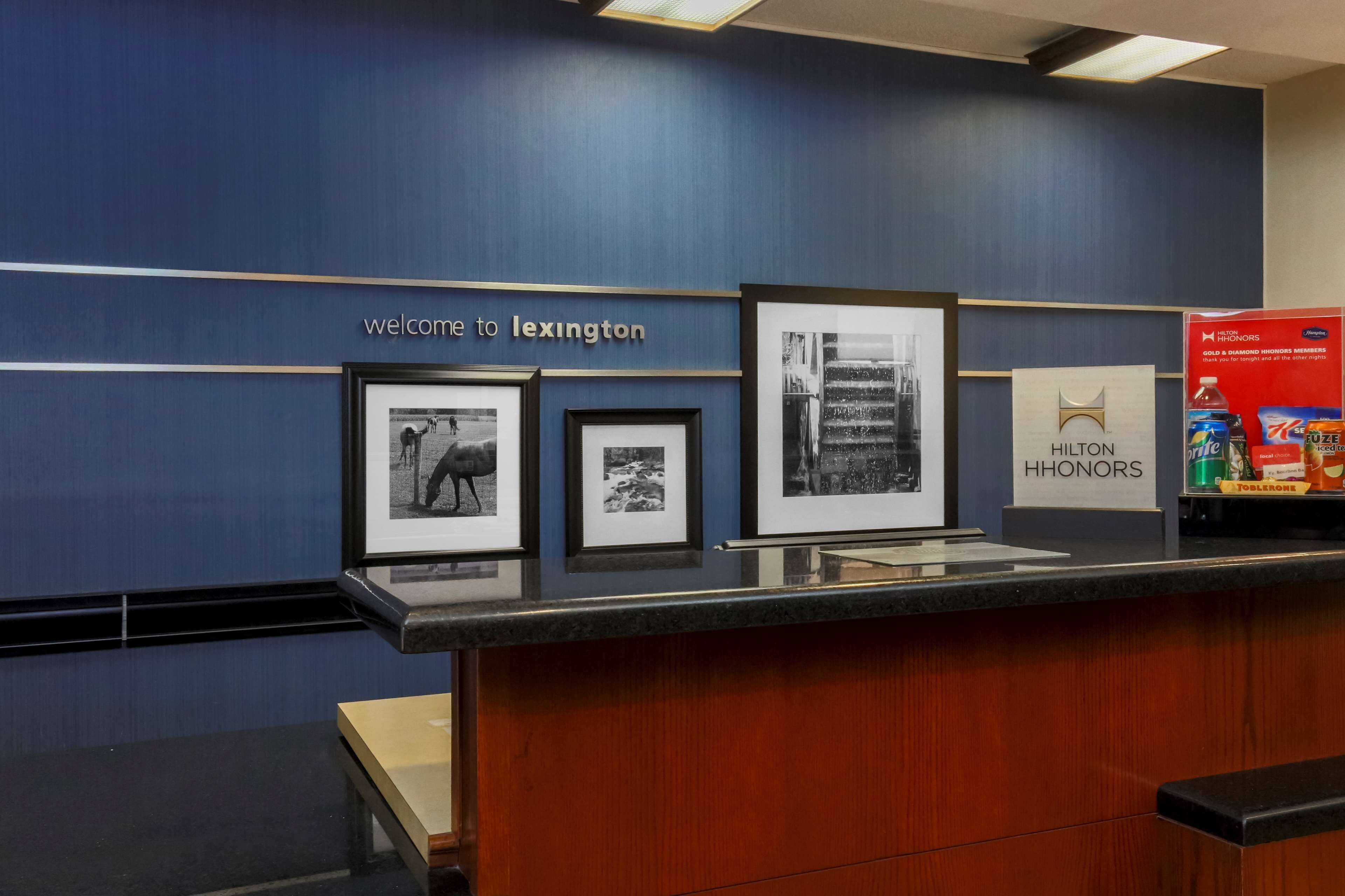 A reception area with a blue wall, framed black and white photographs, and a sign reading "Welcome to Lexington."