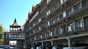 Un hotel a più piani con balconi, una galleria coperta e una struttura a torre caratteristica.