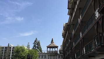 A multi-story building with a central tower and a covered walkway.