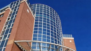 A modern building with a curved glass facade and a covered entrance. - Hotel Dresden Neustadt (Dresden)