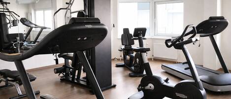 A gym with treadmills, elliptical machines, and weight equipment.
