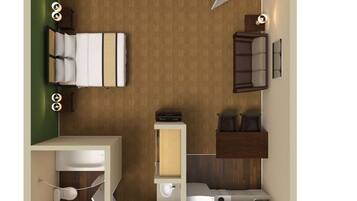 A compact hotel room with a bed, a small desk, a seating area, a wardrobe, and a bathroom.