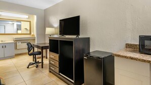 Eine kompakte Küche mit Kühlschrank, Mikrowelle, Spüle und einem Essbereich mit Stuhl und Tisch.
