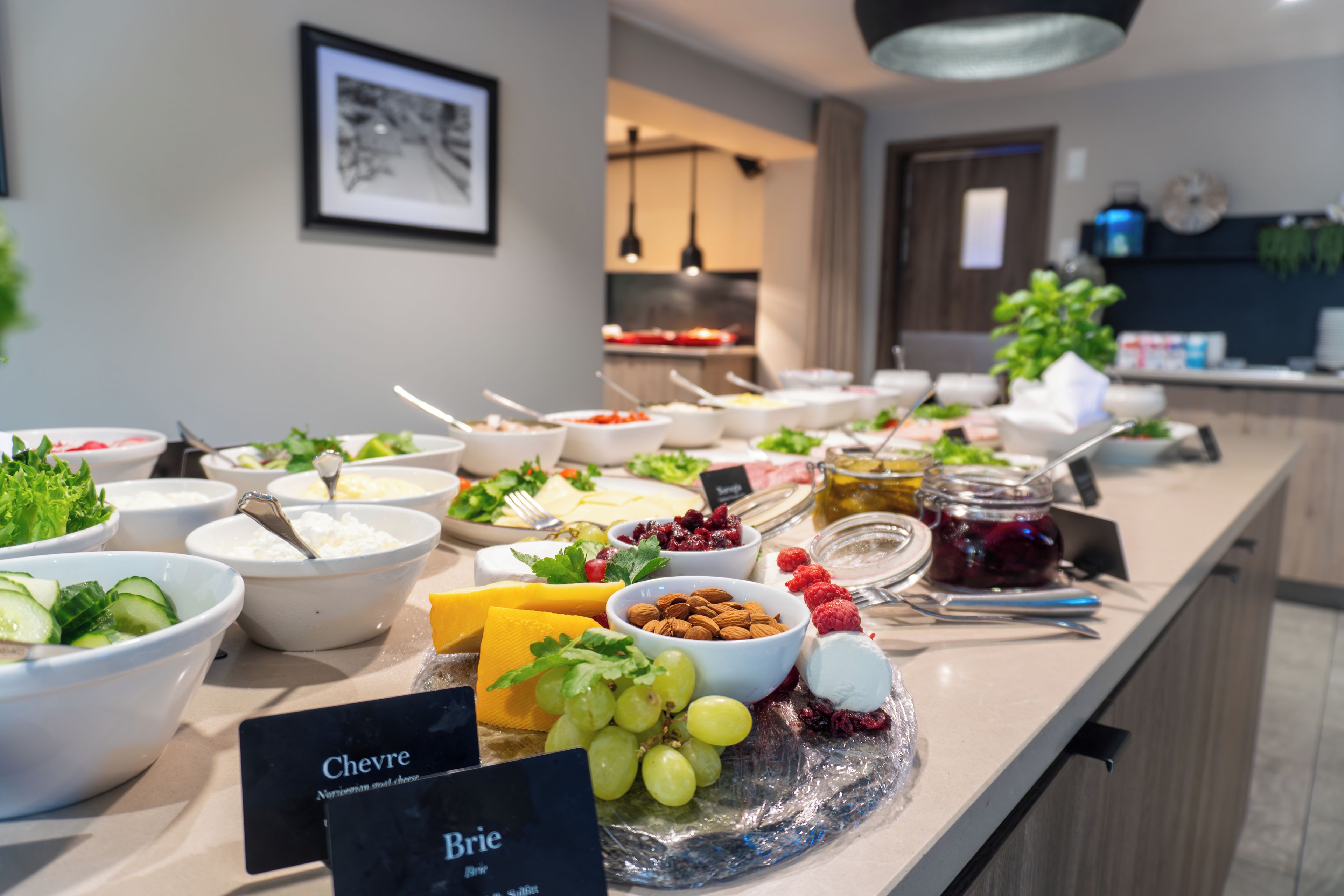 A buffet with various food items and a sign indicating 'Chevre Brie'.