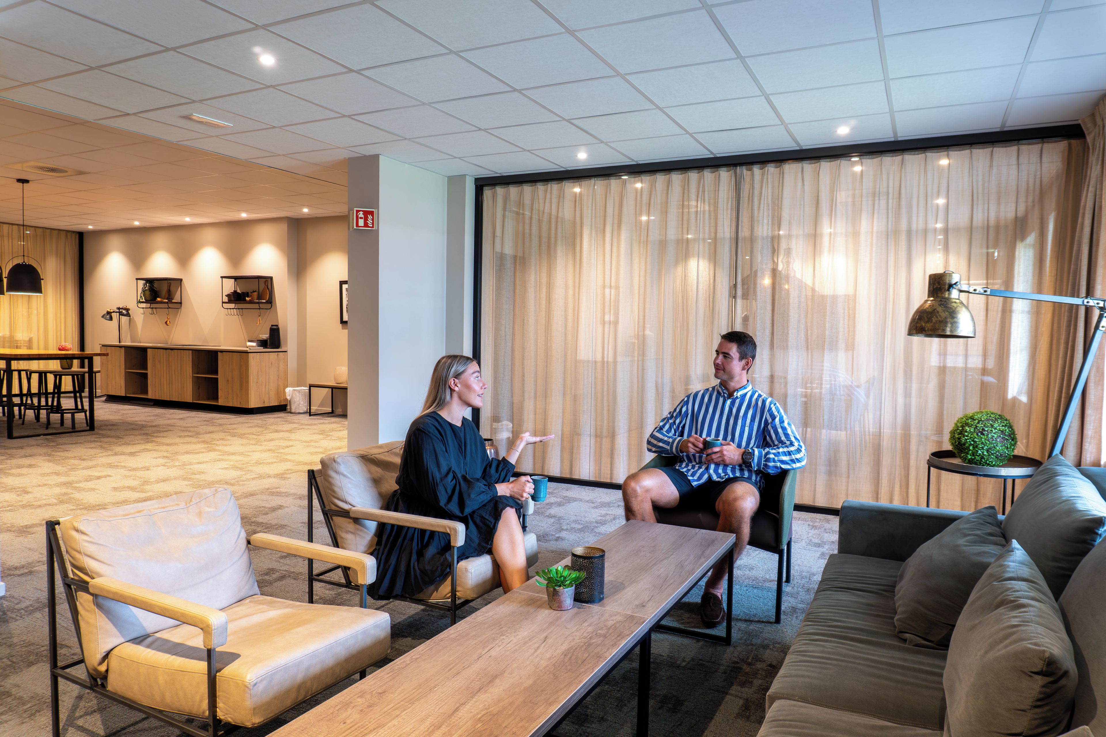 Ein stilvoller Lounge-Bereich mit Sitzgelegenheiten, einem Couchtisch und einem kleinen Beistelltisch mit einer Pflanze.