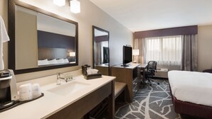 A hotel room with a large bed, a desk with a computer, a chair, a large mirror, a coffee maker, and a sink. - Best Western McMinnville Inn (McMinnville)