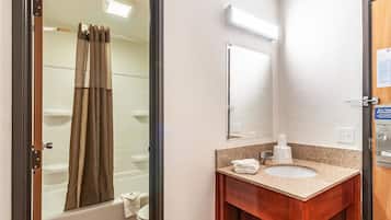A bathroom with a shower, a sink, and a mirror.