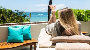 A person relaxing on a balcony with a view of the ocean. - Caribe Hilton (San Juan)