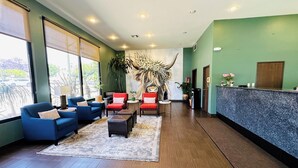 A lobby with blue and red chairs, a reception desk, and a large wall mural. - The Hills Inn Eagle Rock - Near Old Town Pasadena (Los Angeles)