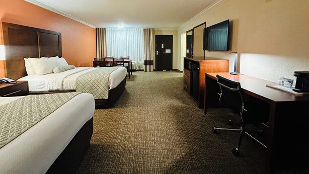 A hotel room with two beds, a desk, a chair, a television, and a minibar. - The Hills Inn Eagle Rock - Near Old Town Pasadena (Los Angeles)