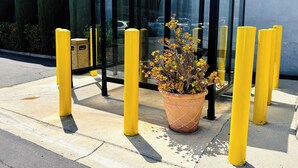 A glass shelter with yellow bollards, a potted plant, and a building in the background. - The Hills Inn Eagle Rock - Near Old Town Pasadena (Los Angeles)