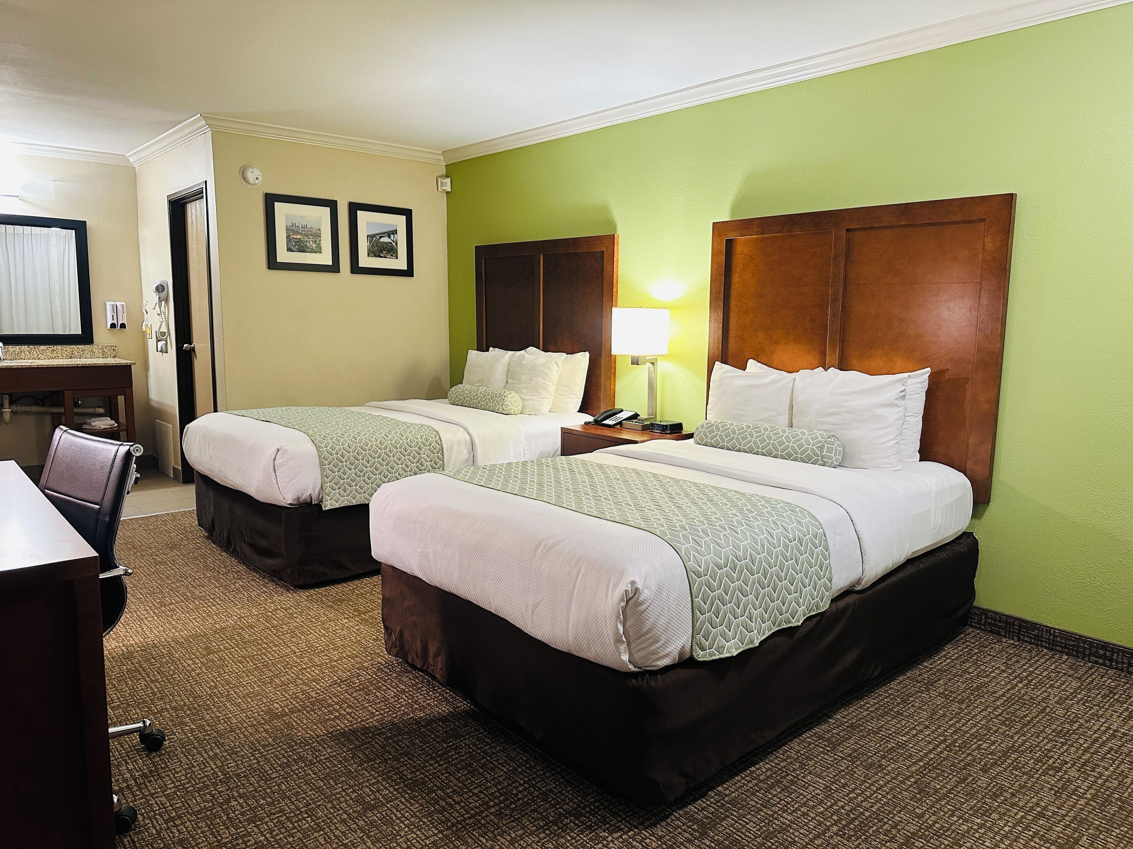 Senger med overmadrass, safe på rommet, skrivebord og blendingsgardiner