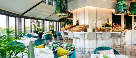 Um restaurante com área de bar, mesas e cadeiras para acomodar clientes, e amplas janelas com vista para o exterior.