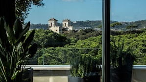 A view of a building with two domed structures, surrounded by lush greenery and a clear sky. - Sofitel Rome Villa Borghese (Rome)