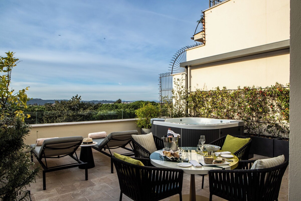 A rooftop terrace with outdoor seating, a hot tub, and a scenic view.