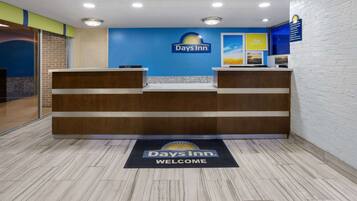 A reception area with a blue wall, a Days Inn logo, and a welcome mat.