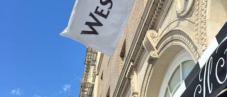 A building with a flag reading "WESTIN" and another with a logo.