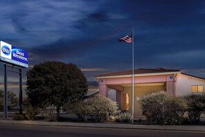 Un hotel con un letrero de Best Western, una bandera y un edificio con garaje.