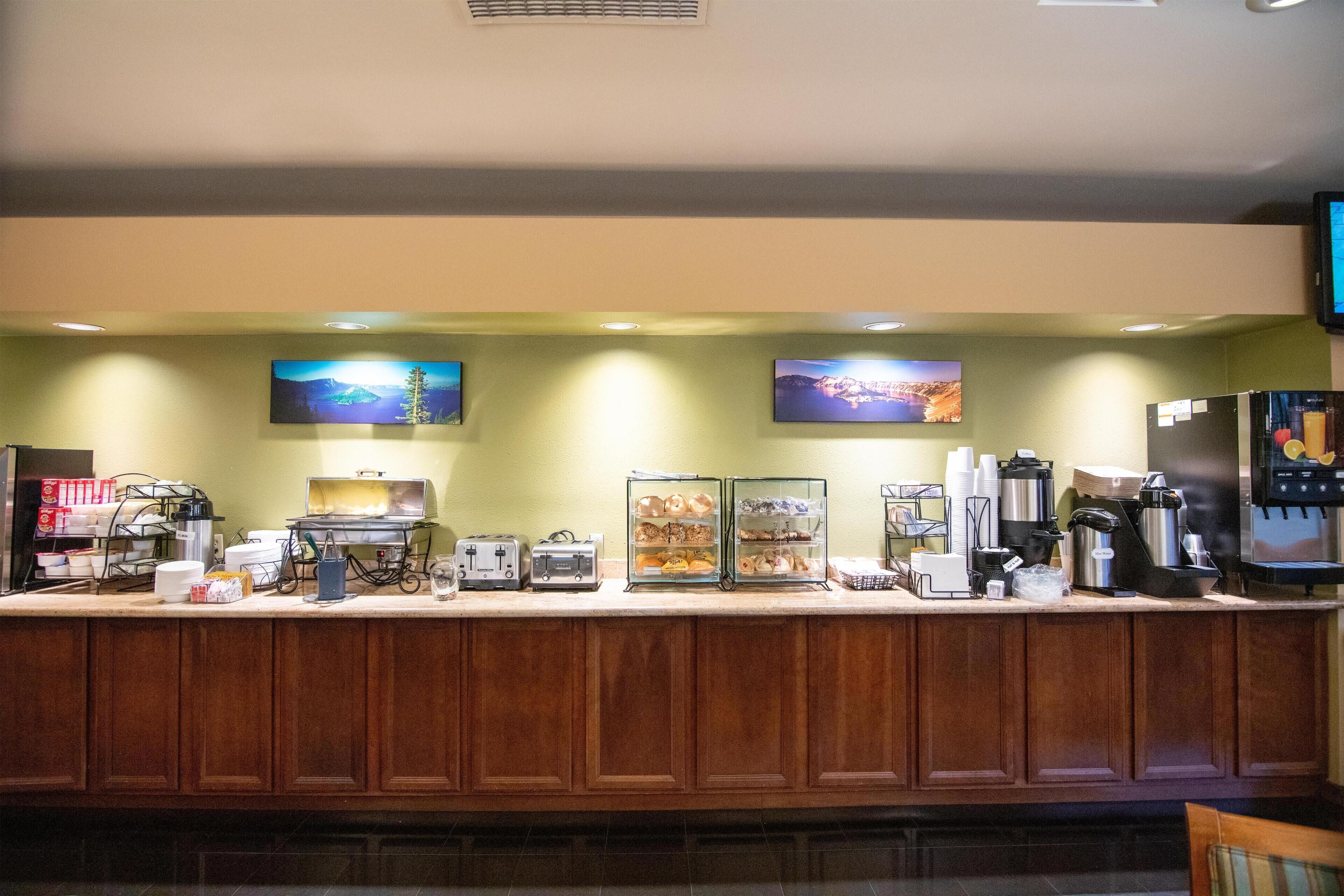 A breakfast bar with a coffee machine, toaster, and display case.