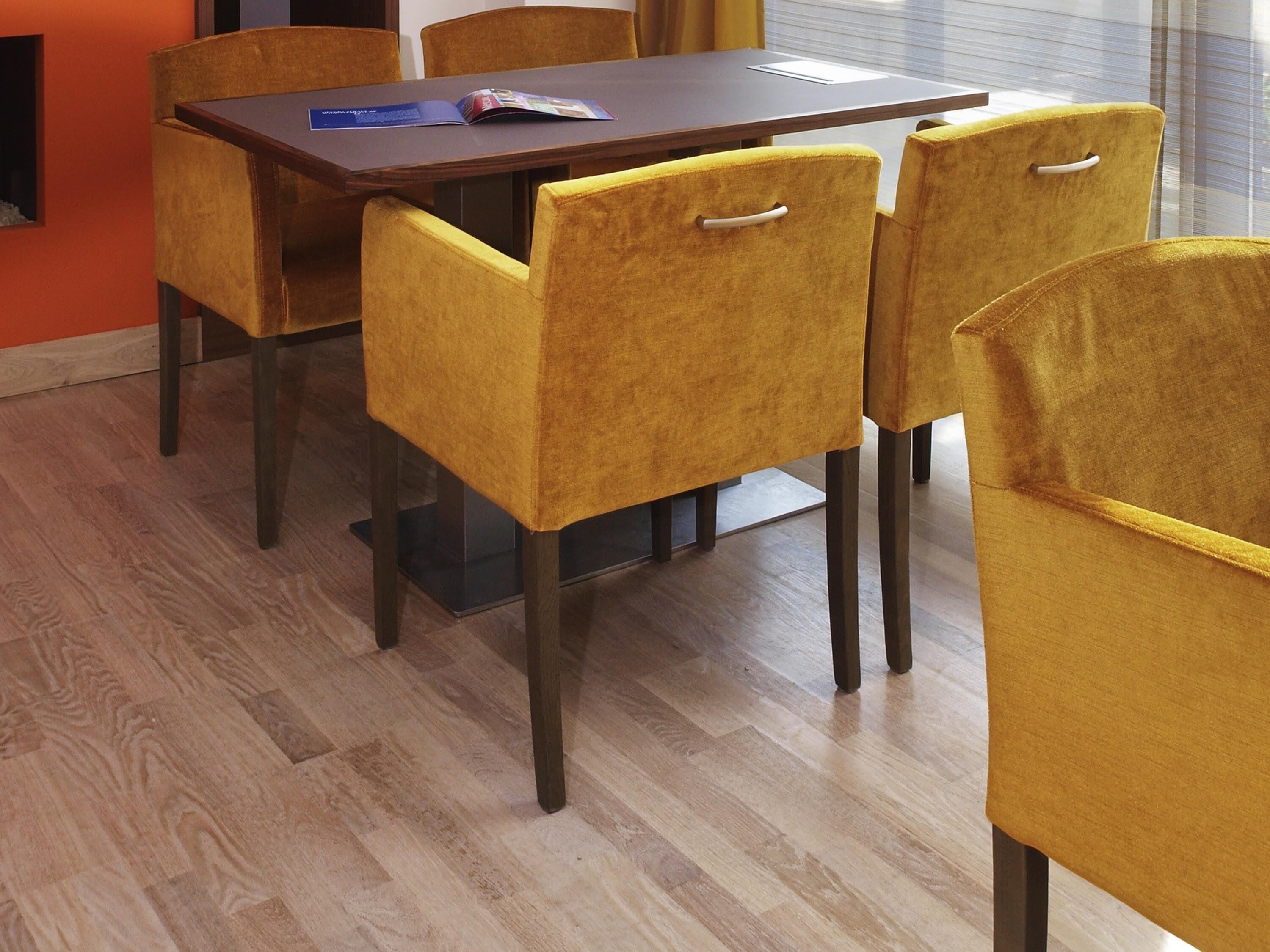 Ein Essbereich mit einem Holztisch und vier gelben Stühlen.