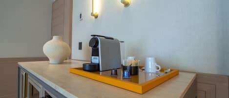 A hotel room's breakfast bar with a coffee machine, a cup, and a tray.
