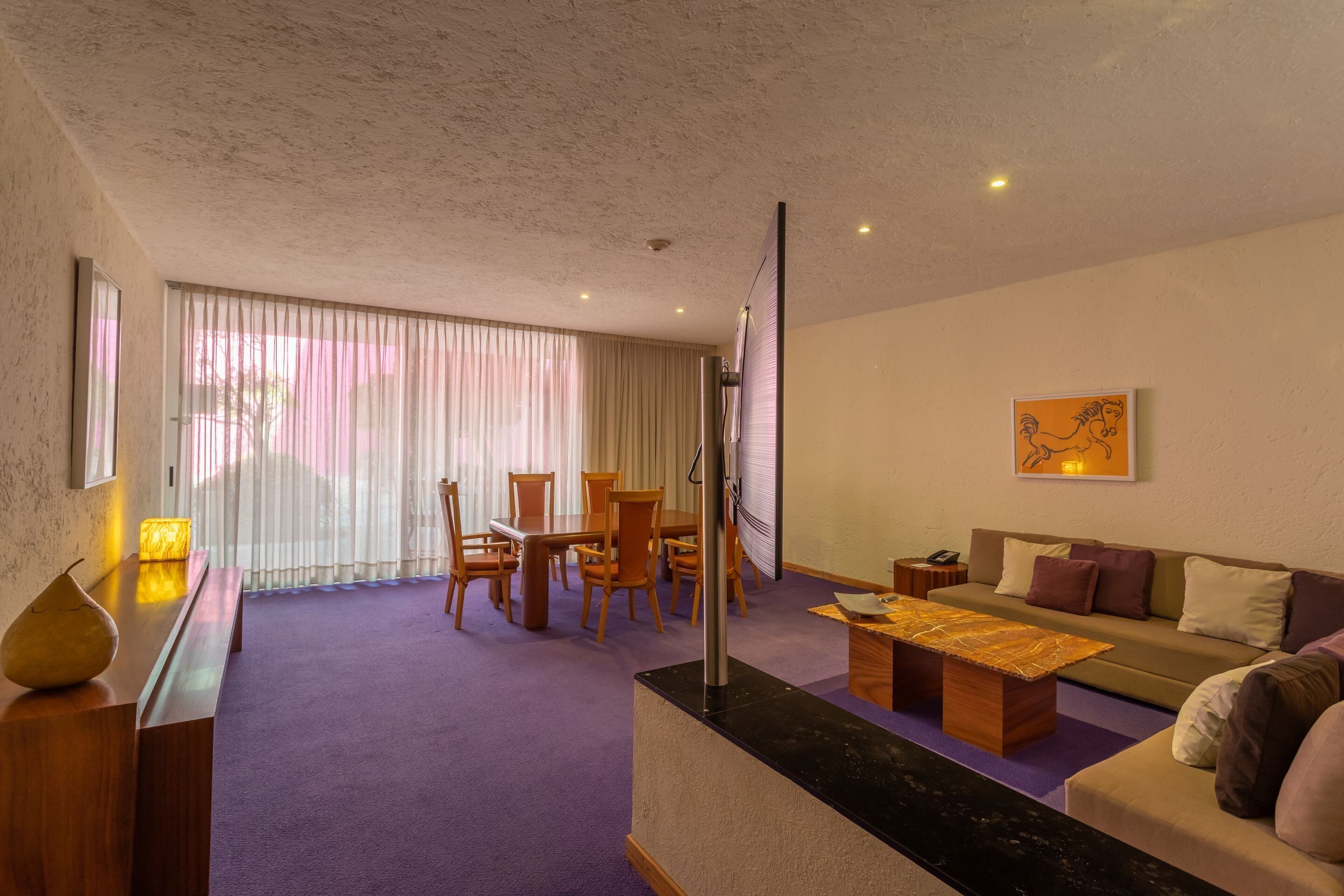 Una sala de estar moderna con un sofá, una mesa de centro y un comedor.