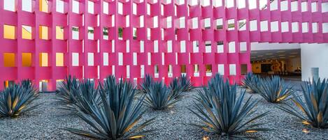 A modern building with a pink facade and a patterned design.