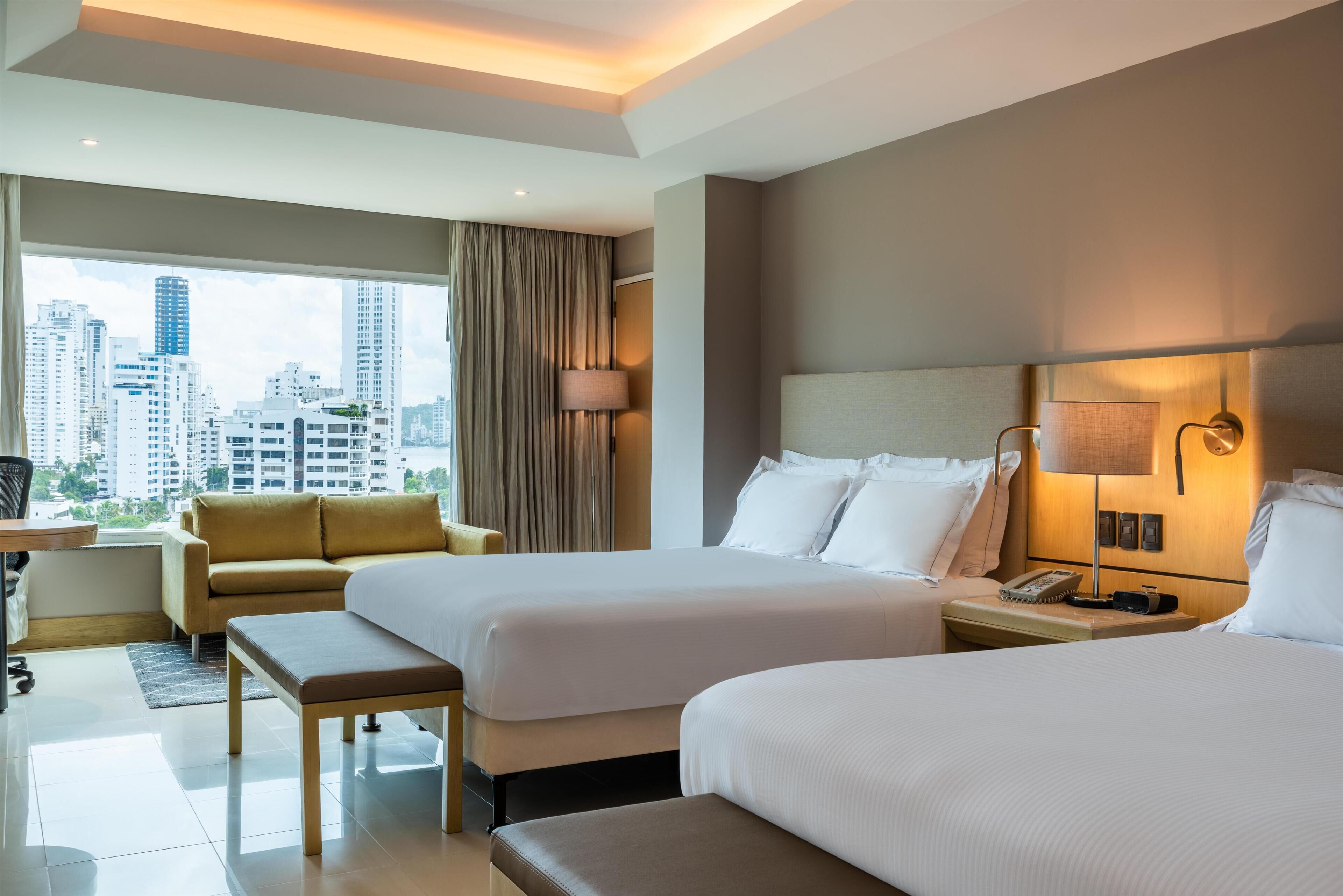 Quarto executivo, 2 camas Queen | Área de estar | TV LCD 49 polegadas com canais a cabo, TV, dock para MP3