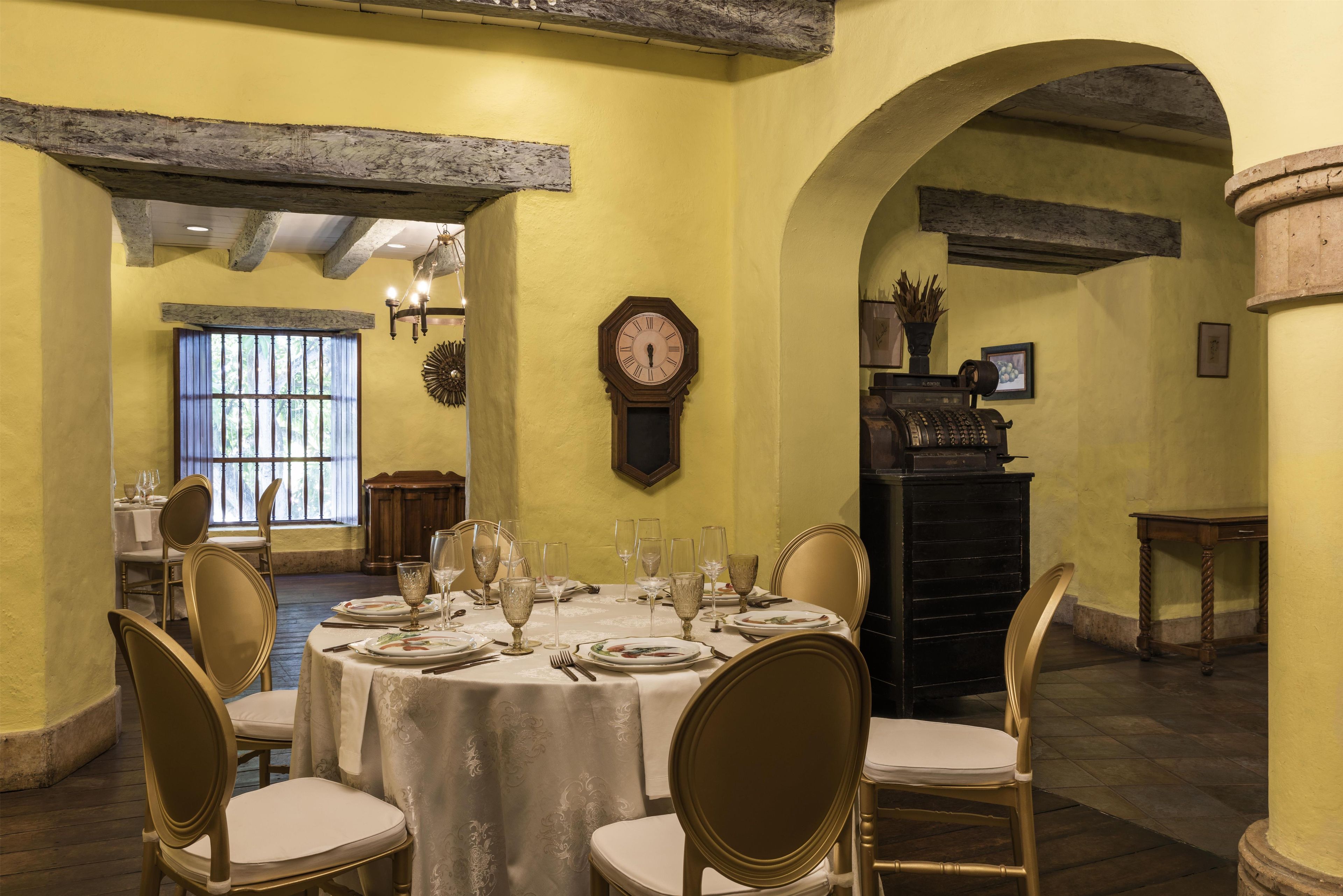 Un comedor con una mesa redonda dispuesta para seis personas, rodeada de sillas.