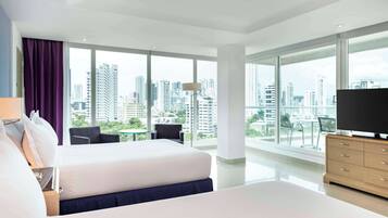 Habitación, 2 camas Queen size, en esquina | Área de sala de estar | Televisión LCD de 49 pulgadas con canales por cable y televisión