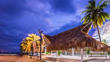 Playa en los alrededores, playa de arena negra, camastros y sombrillas
