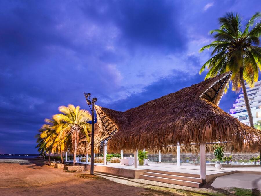 Ranta lähistöllä, mustaa hiekkaa, aurinkotuoleja, aurinkovarjoja