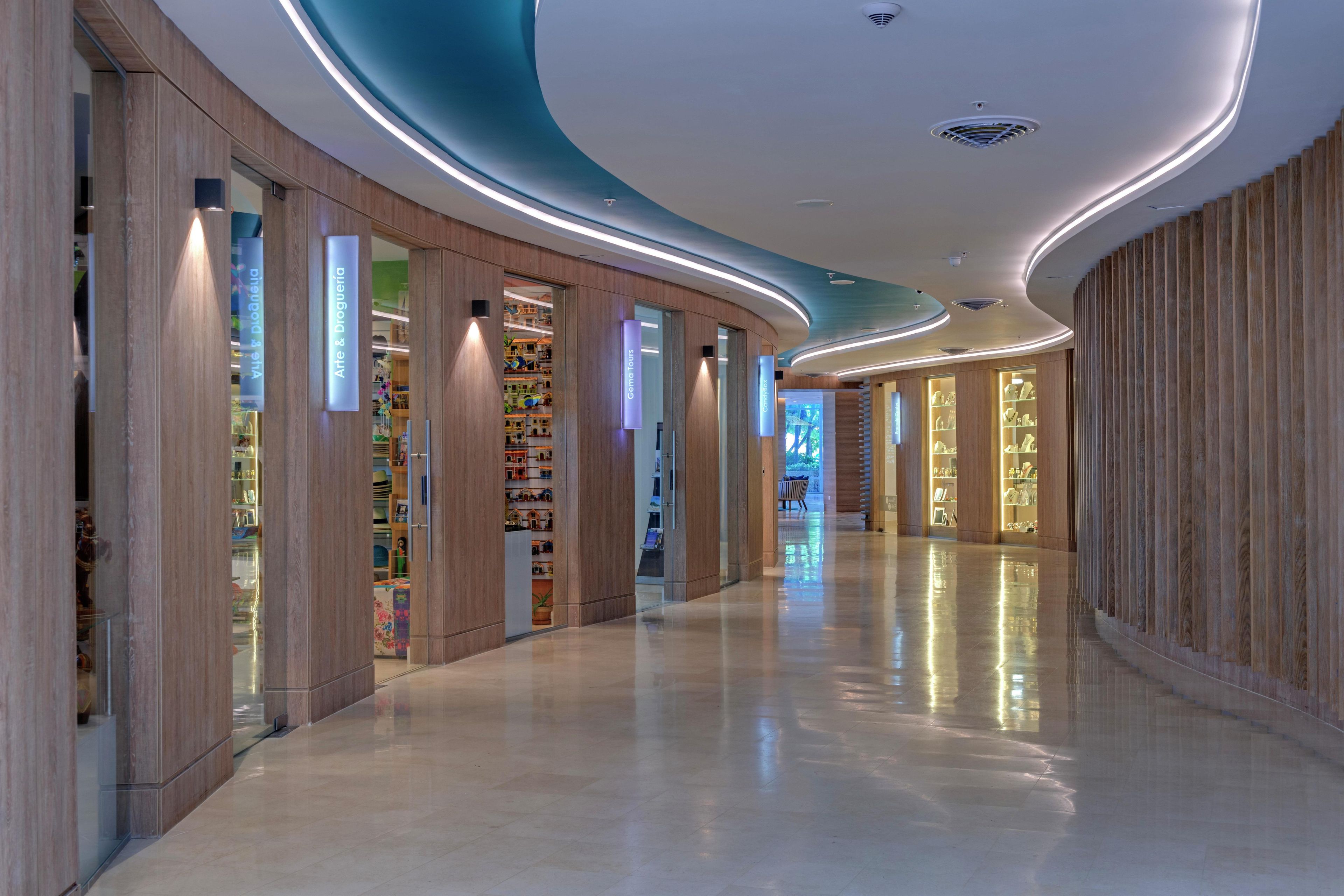 A modern interior with a curved ceiling, wooden paneling, and illuminated signage.