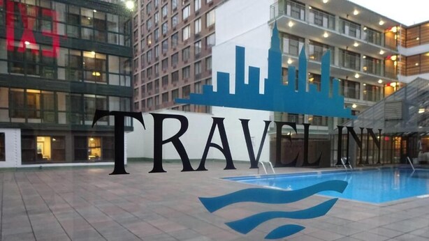 A Travel Inn sign with a city skyline silhouette and a pool area. - Travel Inn Hotel (New York)