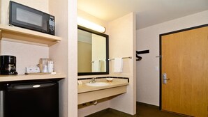 A hotel bathroom with a microwave, coffee maker, sink, and a large mirror. - Best Western Oak Meadows Inn (St. Helens)