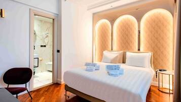 Een moderne hotelkamer met een groot bed, een bureau en een stoel.
