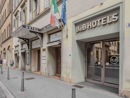 Fachada de hotel com placas indicando 'Hotel Al Duomo' e 'B&B Hotels'.