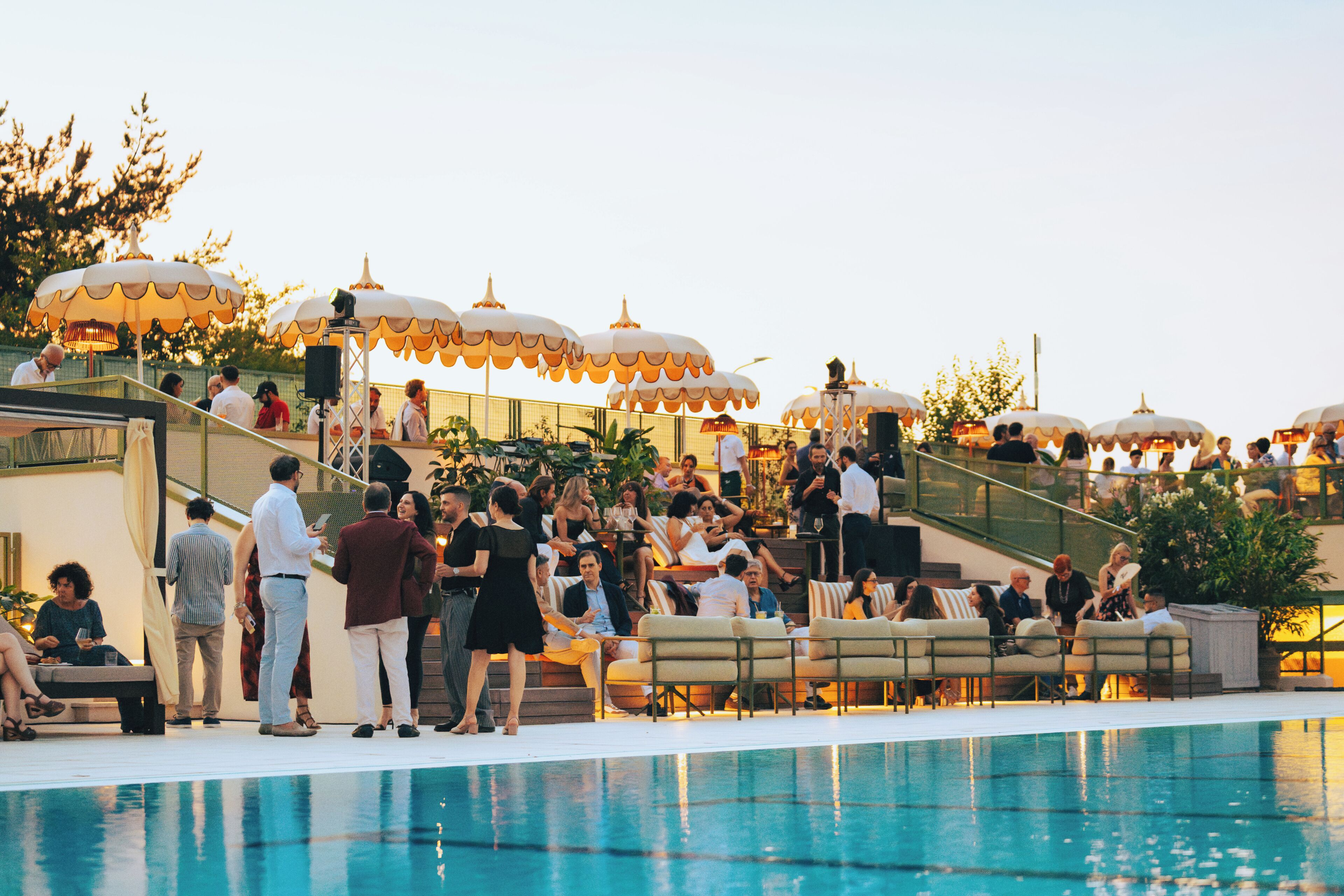 A poolside area with outdoor seating and umbrellas.