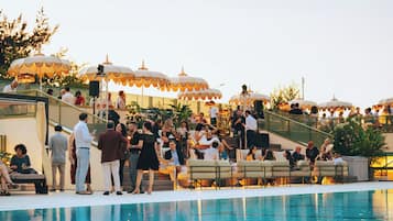 A poolside area with outdoor seating and umbrellas.