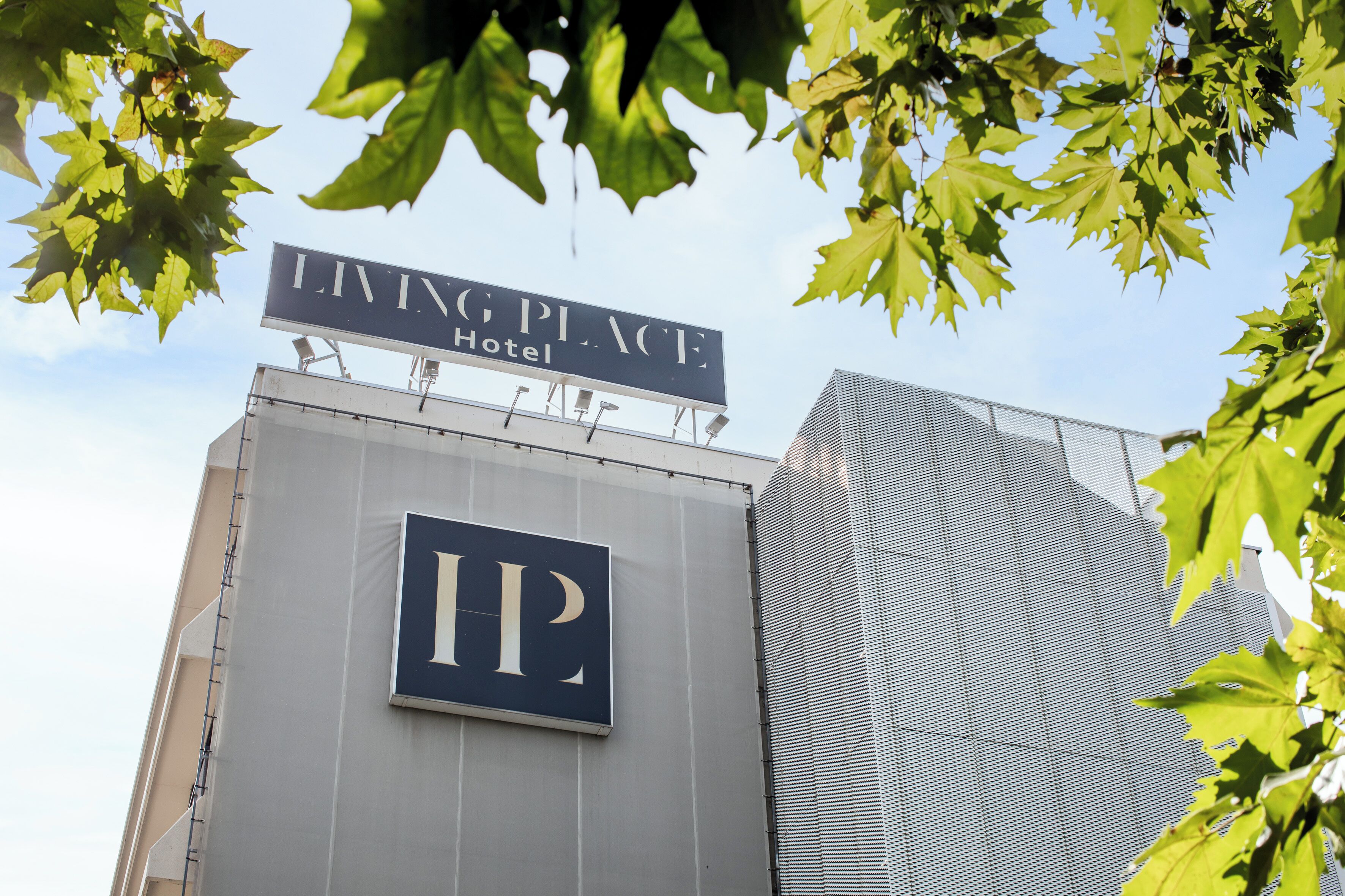 Un letrero para el Living Place Hotel con un gran logotipo 'IP' en el edificio.
