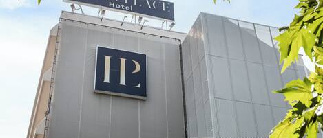 A sign for the Living Place Hotel with a large 'IP' logo on the building.