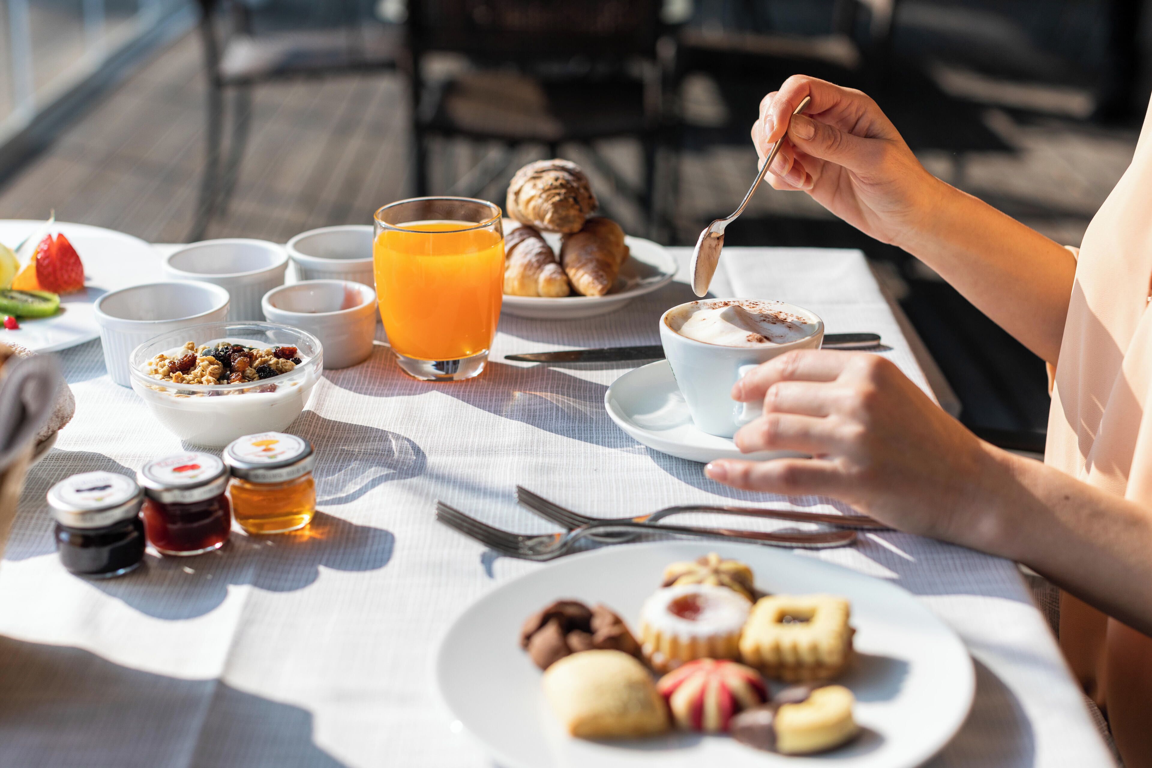 Una mesa de desayuno con diversos alimentos y aderezos.