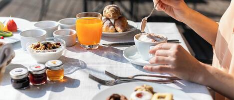 Una mesa de desayuno con diversos alimentos y aderezos.