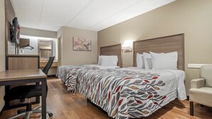 A hotel room with a bed, a desk, a chair, and a TV mounted on the wall. - Red Roof Inn West Monroe (West Monroe)